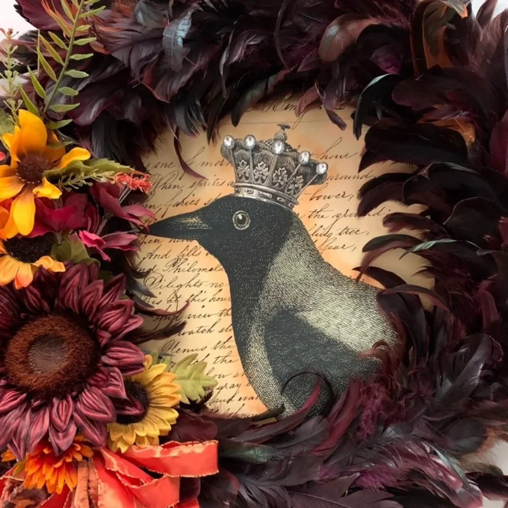 Dark red and black feather wreath with fall floral and a crowned crow center